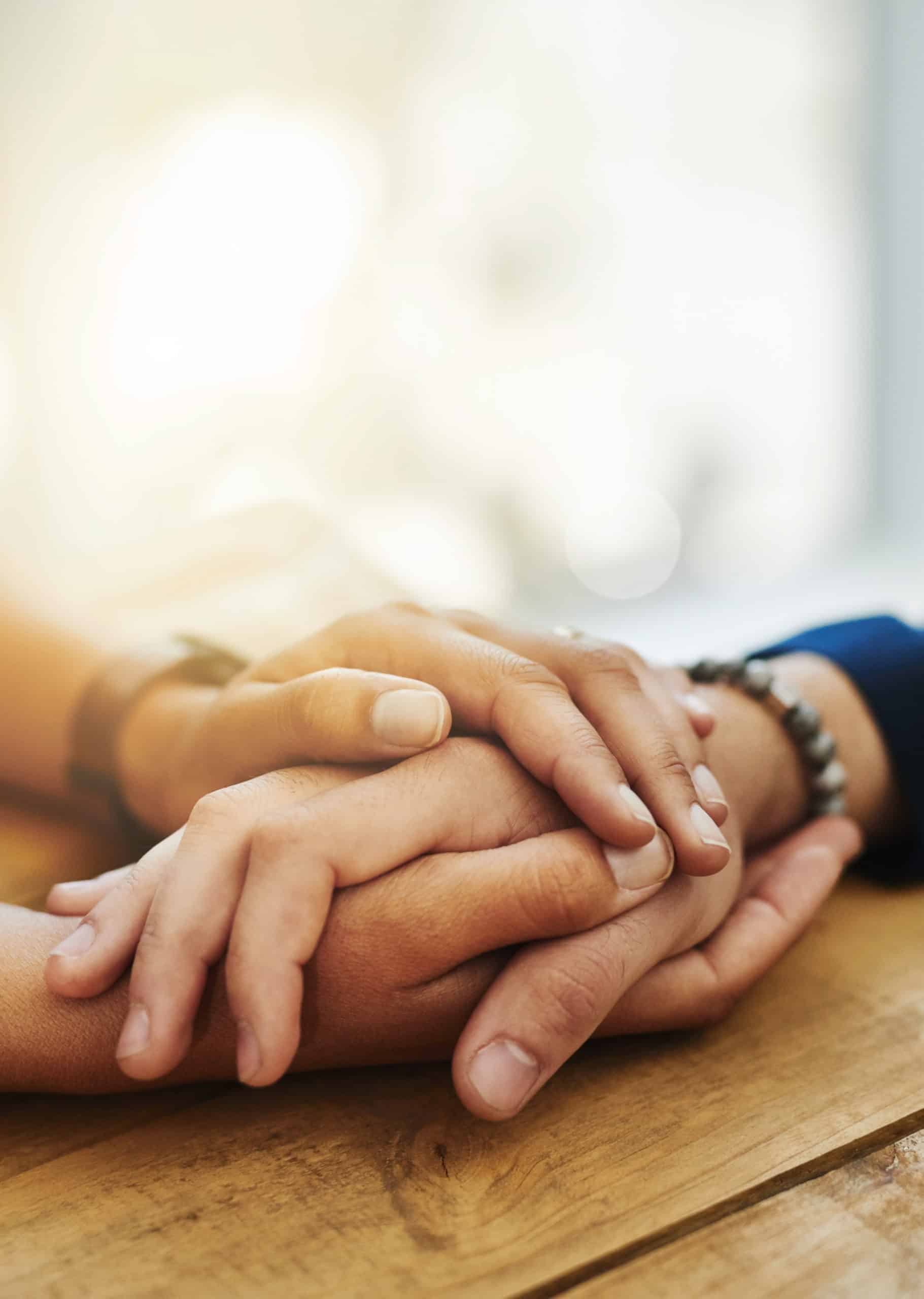 two people people holding hands in comfort